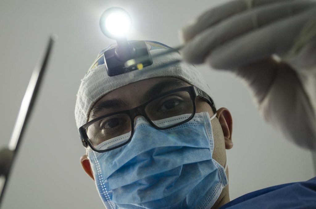 Schedeloperatie procedure: chirurg met gespecialiseerde instrumenten voert microscopische operatie uit op het hoofd van patië